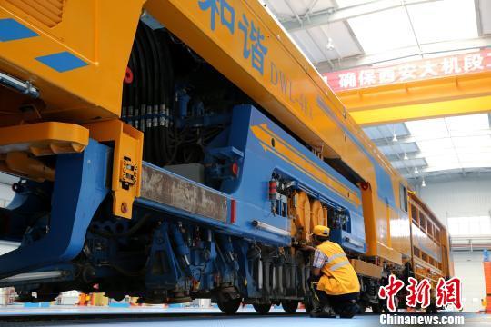 圖為工人正在清理大型養(yǎng)路機械?！堖h 攝